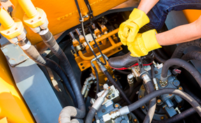 Operator fixing machinery on worksite. 